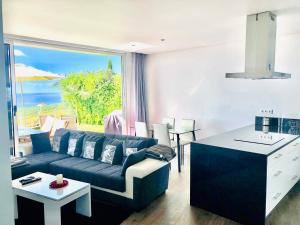 a living room with a couch and a table at Villa Pinheira II in Estreito da Calheta