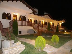 a large white house with a courtyard at night at Village Naiades in Kastoria