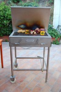 a grill with food on it on a patio at Agriturismo Parra in Santa Lucia del Mela