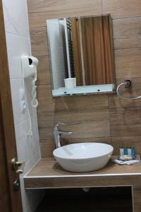 a bathroom with a white sink and a mirror at Green Apartment in Kazbegi +50 photos