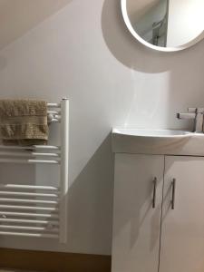 uma casa de banho branca com um lavatório e um espelho em quiet secluded loft in County Durham em Durham