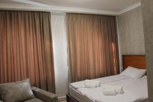 a hotel room with a bed and a chair at Green Apartment in Kazbegi