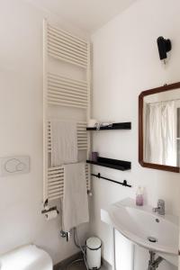 Baño blanco con lavabo y espejo en Da Linda, en Livorno