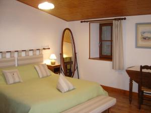 - une chambre avec un lit vert et un miroir dans l'établissement Chambres d'Hôtes Domaine Le Fragnaud, à Saint-Porchaire