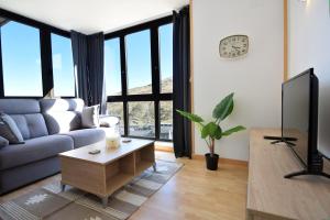 a living room with a couch and a tv at Lux Isard "Acceso directo a pistas" in Pas de la Casa