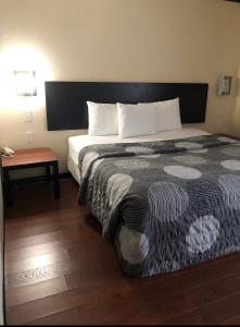 a hotel room with a large bed and a table at Araamda Inn in Norcross