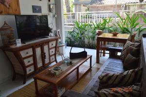 a living room with a television and a table at Askara Guest House & Hostel in Ubud