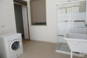 a bathroom with a washing machine and a sink at Villa Tortuga By Cala Salento in Torre Lapillo