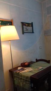um candeeiro sentado numa mesa ao lado de uma cama em La Casa di Ulisse B&B em Quercianella