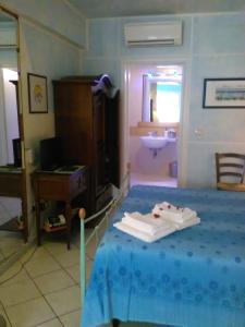 um quarto com uma cama, um lavatório e um espelho em La Casa di Ulisse B&B em Quercianella