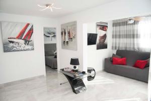 een woonkamer met een bank en foto's aan de muur bij Playa de Las Americas Luxury Home in Playa de las Americas
