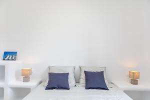 ミクリ・ヴィグラにあるMikri Villasの白い部屋(青い枕付きのベッド付)