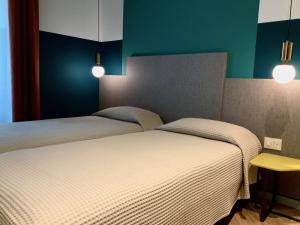 2 camas en una habitación con paredes y luces verdes en Residenza Alto Garda, en Riva del Garda