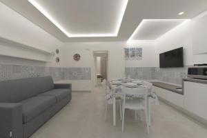 Una sala de estar con un sofá y una mesa con sillas. en Casa Azul, en San Vito lo Capo