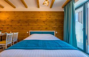 1 dormitorio con 1 cama y pared de madera en NEW GUDAURI ATRIUM 336 en Gudauri