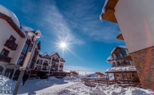 a city street covered in snow with buildings at NEW GUDAURI ATRIUM 336 in Gudauri