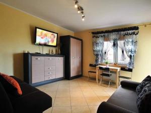 a living room with a couch and a dining room at APARTAMENT KLAUDIA in Krynica Morska