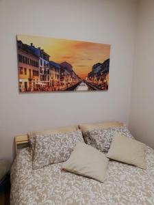 una camera da letto con un letto e un dipinto sul muro di Sweet Home Milano B&B a San Donato Milanese