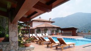 a group of chairs sitting next to a swimming pool at Resort Ninfea San Pellegrino Terme in San Pellegrino Terme