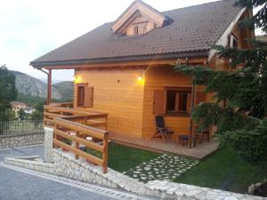 ein kleines Holzhaus mit einer Veranda und einer Terrasse in der Unterkunft B&B Lo Chalet Di Ocre in San Felice dʼOcre