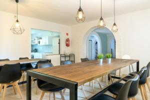 a dining room with a wooden table and chairs at Tiszapart-Vendégház in Tiszakécske