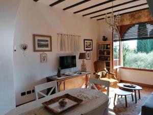 ein Wohnzimmer mit einem Tisch und einem TV in der Unterkunft Suite Deluxe a Villa Paradiso in Sirmione