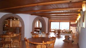 una sala da pranzo con tavoli e sedie in legno di Resort Ninfea San Pellegrino Terme a San Pellegrino Terme
