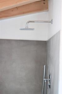 uma casa de banho com chuveiro e cabeça de chuveiro em La Corte 22 em Caprino Veronese