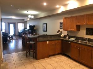 a kitchen with wooden cabinets and a living room at Lakefront Townhouse Family Complex, Popular Wine Country and the Best Golfing in Osoyoos