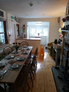 a large wooden table in a room with a kitchen at Mairs Bed and Breakfast. in Bridgend