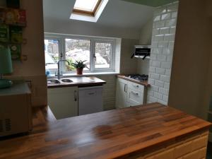 a kitchen with a wooden table and a sink at Mairs Bed and Breakfast. in Bridgend