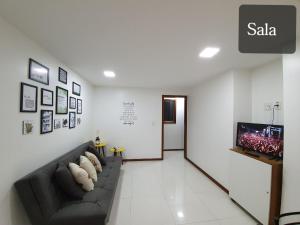 a living room with a couch and a flat screen tv at Flat Pasárgada 404 in Vila Velha