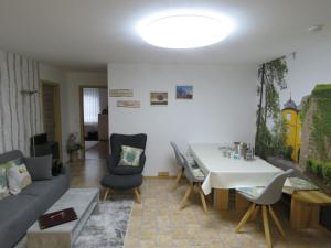 a living room with a couch and a table and chairs at Haus Waldzauber in Neuhäusel