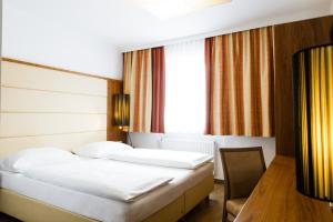Postel nebo postele na pokoji v ubytování Hotel Kapeller Innsbruck