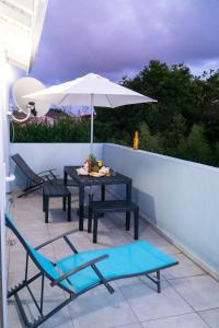 a table and chairs and an umbrella on a patio at joli appartement avec vue au Moule in Le Moule
