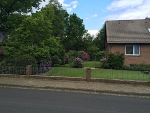 a fence in front of a house with flowers at Haus Moorkamp in Celle