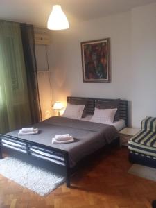 een slaapkamer met een groot bed en 2 handdoeken bij Apartman Centar Beograd in Belgrado