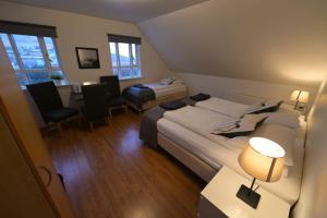 a hotel room with two beds and a table and chairs at Guesthouse Carina in Vík