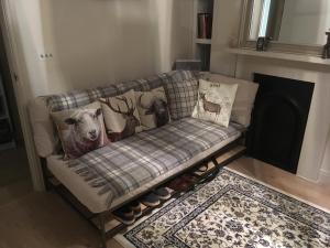 a couch with pillows on it in a living room with a fireplace at Stylish City Centre Flat in Leeds