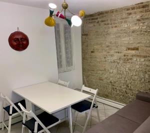 una mesa y sillas blancas en una habitación con una pared de ladrillo en [Storico] Ombelico di Parma en Parma