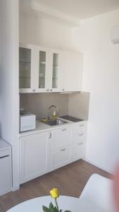 a kitchen with white cabinets and a sink at ZAGRABY APARTMENT in Zagreb