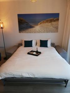 ein großes Bett mit einem Tablett darüber in der Unterkunft Zeebriesje in Oostduinkerke