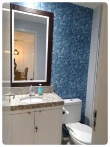 a bathroom with a toilet and a sink and a mirror at Flat Porto de Galinhas in Porto De Galinhas