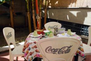 a table with cocacola chairs and a table with at A Casa di Pe' Casa Vacanze in Rome
