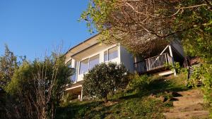 a house on the side of a hill with trees at Big Sky Nelson Luxury Eco B&B in Nelson