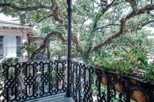 a wrought iron balcony with a tree in the background at Malaga Inn in Mobile