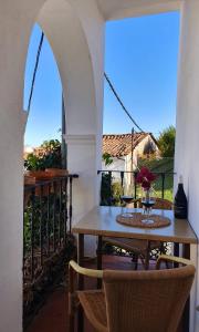 a table with two glasses of wine on a balcony at Pensión El Barrio in Fuenteheridos