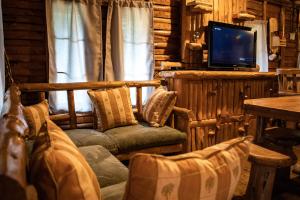 a living room with chairs and a tv in a log cabin at Cabañas El Coyote in San Pablo