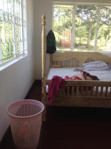 un bambino che dorme su un letto in una camera da letto di Rafting River Nile House Jinja a Jinja