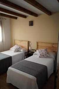 a hotel room with two beds and a window at Puente viejo de Buitrago CASA ENCINA in Buitrago del Lozoya